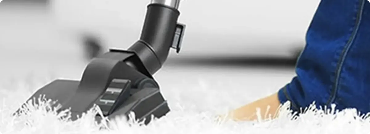 Close-up of a professional vacuuming a white carpet in Glenshaw.